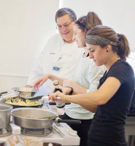 Chef observing two female students cooking